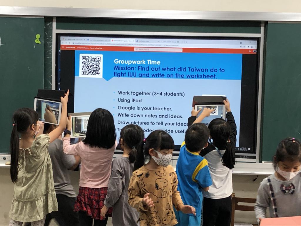 A group of children looking at a screenDescription automatically generated with medium confidence